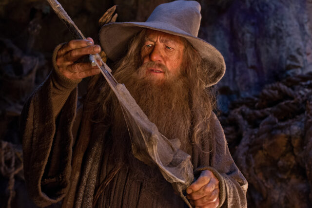 Ian McKellen As Gandalf Holding A Staff In A Detailed Fantasy Scene Wallpaper