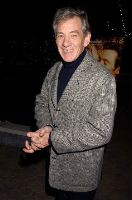 Ian Mckellen Smiling In A Stylish Grey Blazer At An Evening Event Wallpaper