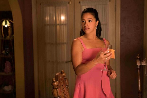 A woman from Jane The Virgin is holding a glass and looking surprised in a warmly lit room, HD Desktop Wallpaper