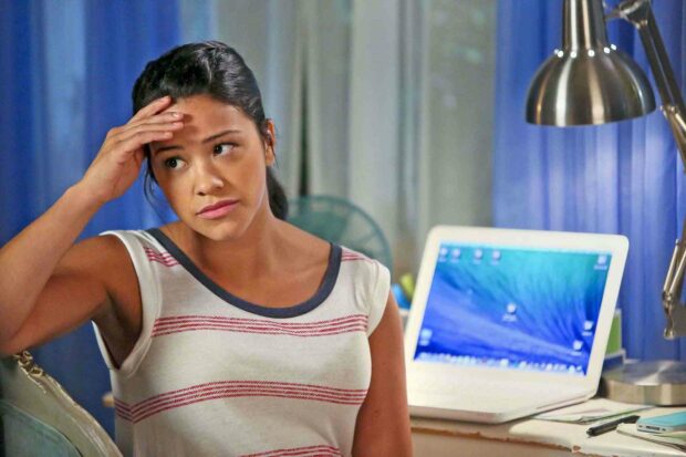 A woman from Jane The Virgin looks contemplative while sitting near a laptop and lamp, HD Desktop Wallpaper