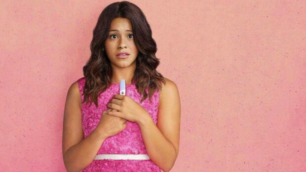 A worried woman holds a positive pregnancy test in front of a pink background in Jane The Virgin wallpapers, HD Desktop Wallpaper