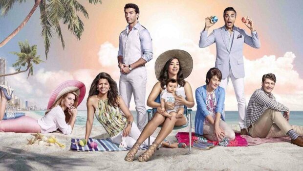 The Jane The Virgin cast poses on a sunny beach with palm trees and soft clouds, HD Desktop Wallpaper