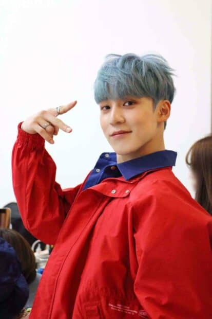 Jeong Yun Ho is smiling and making a casual hand gesture while wearing a red jacket, HD Mobile Wallpaper