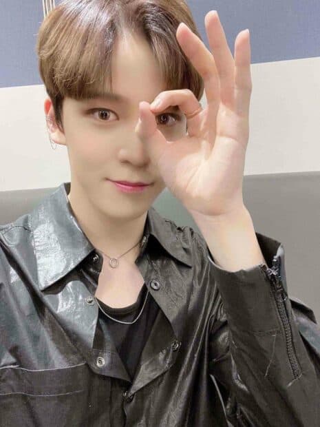 A close up portrait of Jeong Yun Ho making an okay hand gesture while wearing a shiny black shirt, HD Mobile Wallpaper