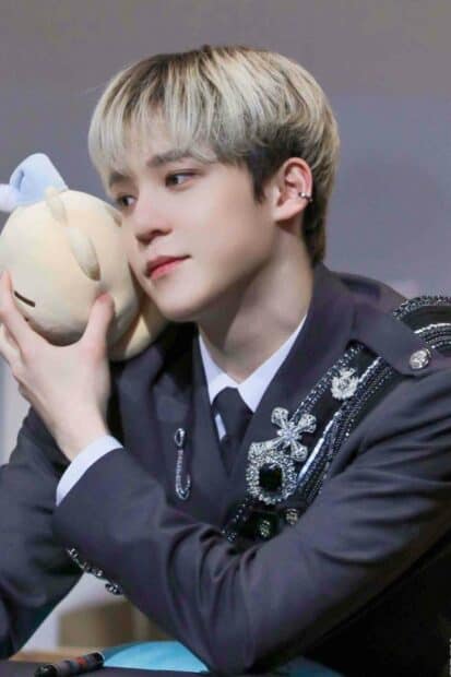 Jeong Yun Ho holding a soft plush toy while dressed in a decorated suit, HD Phone Wallpaper