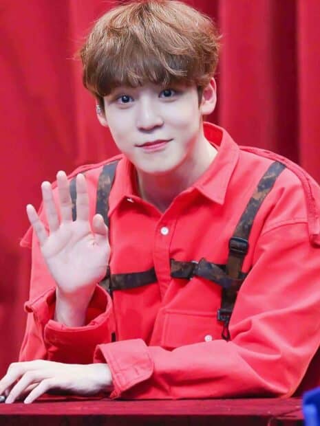 Jeong Yun Ho is smiling warmly and raising his hand in a friendly gesture, HD Phone Wallpaper