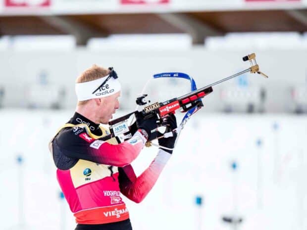 Johannes Thingnes aiming with his rifle at a biathlon shooting range, HD Desktop Wallpaper