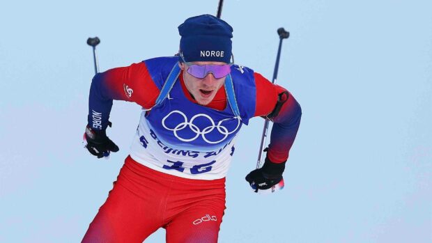 Johannes Thingnes competing intensely in a cross country skiing event wearing Norwegian colors, 2K Desktop Wallpaper
