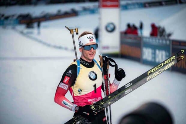 Johannes Thingnes is celebrating after a biathlon race with skis and gear, HD Desktop Wallpaper