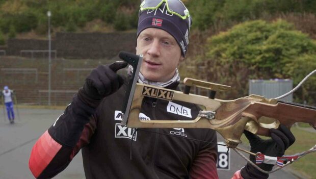 Johannes Thingnes is adjusting his ski rifle outdoors during training, HD Desktop Wallpaper