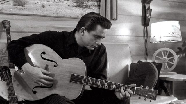 Johnny Cash Playing Guitar Iconic Black And White Wallpaper
