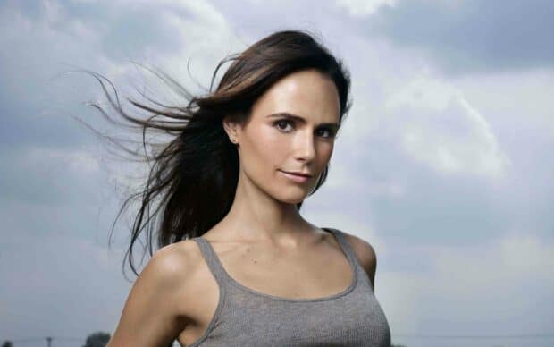 Jordana Brewster smiles softly with her hair blowing in the wind under a cloudy sky, 2K Desktop Wallpaper