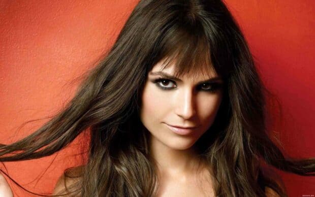 Jordana Brewster is posing with her long hair flowing against a red background, HD Desktop Wallpaper