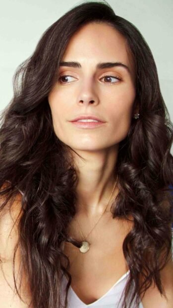 A close up portrait of Jordana Brewster looking sideways with natural makeup and wavy hair, 2K Phone Wallpaper