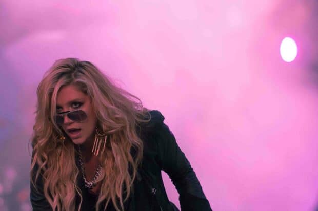 Kesha is performing on stage with vibrant lighting and intense expression, HD Desktop Wallpaper