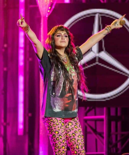 Kesha is raising her arms during a vibrant live performance, HD Mobile Wallpaper