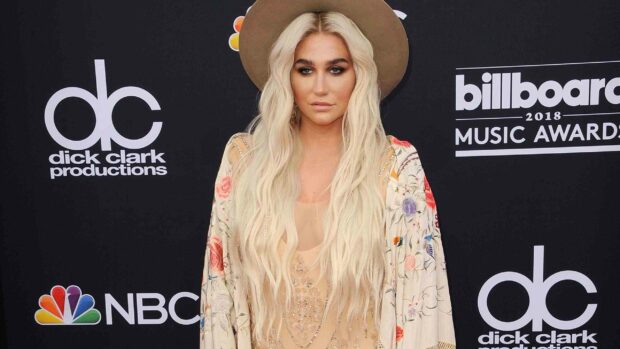 Kesha displays a stylish look with long blonde hair and a floral outfit at a music awards event, 2K Desktop Wallpaper