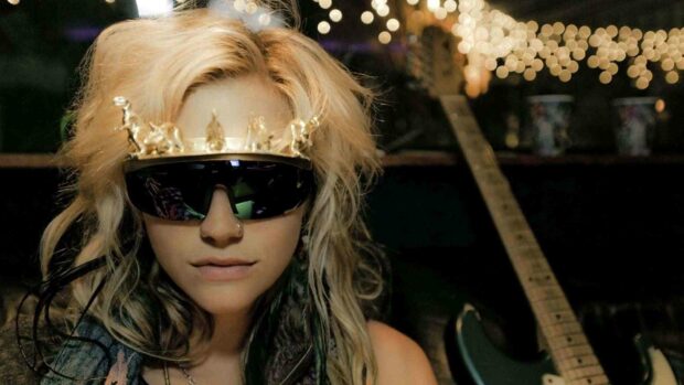 A close up of Kesha wearing reflective sunglasses and a decorative headpiece with a guitar in the background, HD Desktop Wallpaper