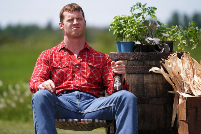 Letterkenny TV Series Wallpaper Featuring Man In Red Plaid Shirt Holding Beer Bottle