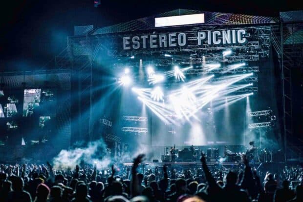A large crowd enjoys a live music concert with bright stage lights illuminating the performers, HD Desktop Wallpaper
