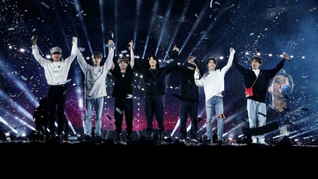 A music group is celebrating on stage with bright lights and confetti during a concert, 2K Desktop Wallpaper
