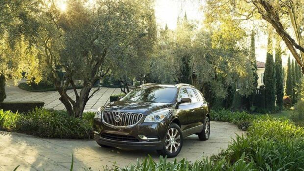 A Buick Enclave is parked among lush trees and greenery on a sunny day, HD Desktop Wallpaper