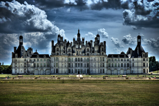 Majestic Chateau De Chambord Wallpaper With Dramatic Sky And Expansive Lawn View