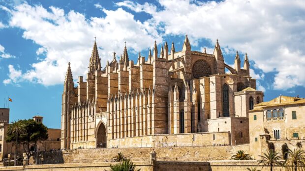 The cathedral features detailed gothic design under a blue sky, 4K Desktop Wallpaper