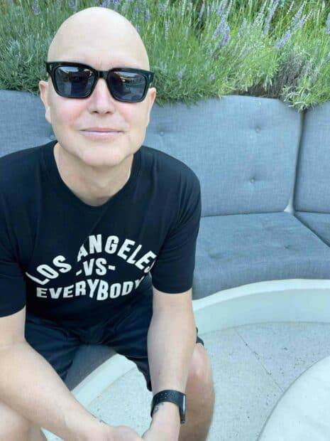 Mark Hoppus is sitting outdoors wearing sunglasses and a black t shirt, HD Mobile Wallpaper