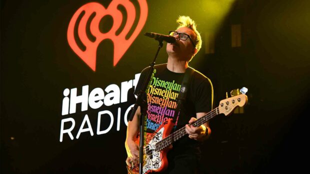 Mark Hoppus is singing and playing guitar at a concert with iHeartRadio logo in the background, HD Desktop Wallpaper