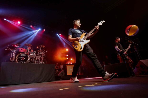 Mark Hoppus is performing on stage with his bass guitar during a concert, 2K Desktop Wallpaper