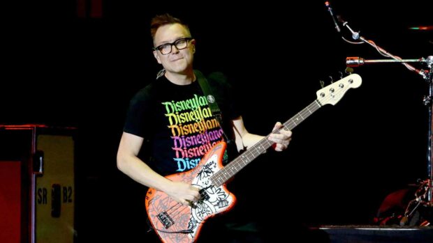 Mark Hoppus is performing live with a colorful guitar on a dark stage, HD Desktop Wallpaper