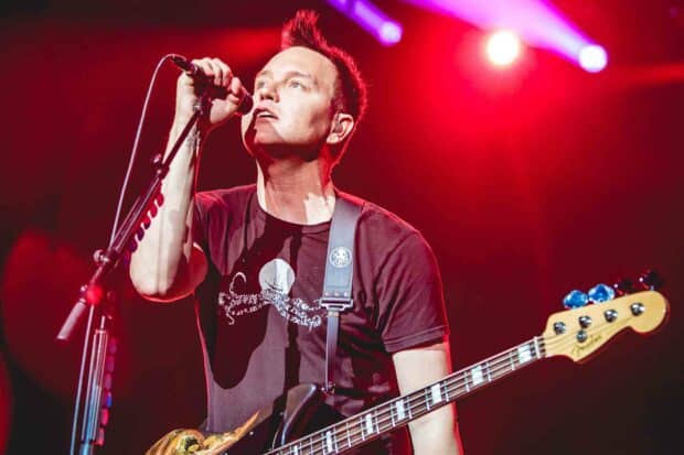 Mark Hoppus is performing live with his guitar under vibrant red lights, HD Desktop Wallpaper