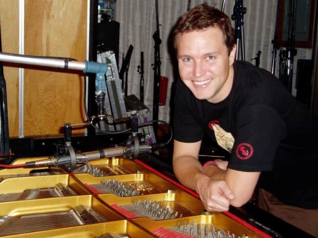 Mark Hoppus is leaning on a grand piano while smiling in a recording studio, HD Desktop Wallpaper