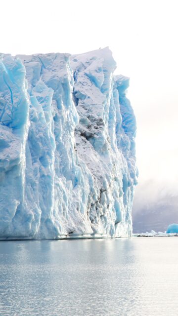 Massive Blue Glacier Iceberg Floating In Arctic Ocean Calm Waters Wallpaper