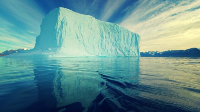 Massive Iceberg Reflection In Arctic Ocean Calm Waters Wallpaper