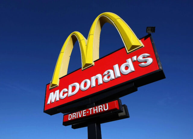 McDonalds Drive Thru Sign with Golden Arches on Clear Blue Sky Background Wallpapers