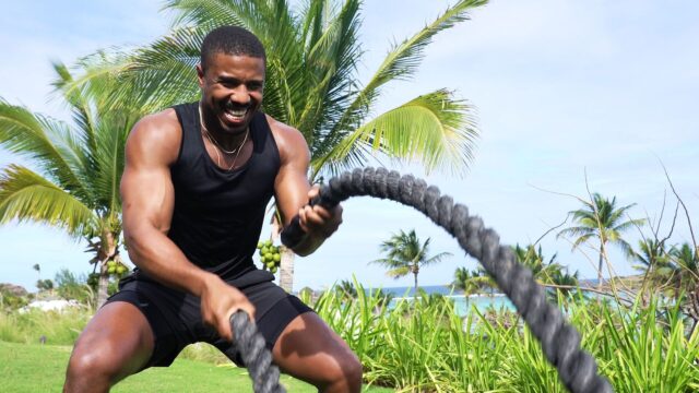 Michael B Jordan Training Outdoors with Battle Ropes Tropical Background Wallpaper