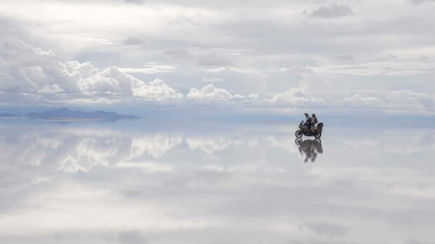 Two people riding a motorcycle across the reflective salt flats in Bolivia, HD Desktop Wallpaper