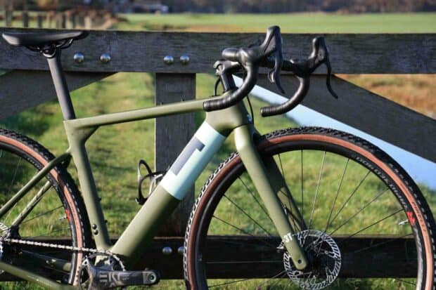 A modern 3T bike is parked beside a wooden fence with a grassy field in the background, HD Desktop Wallpaper