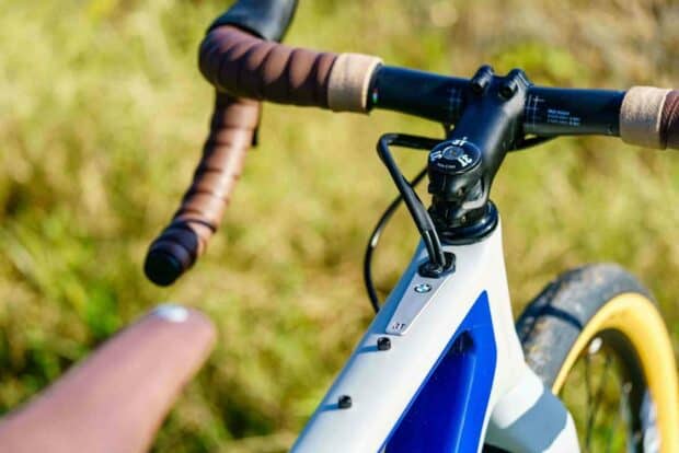 A close up view of a 3T bike handlebar with leather grips and part of the frame in a natural outdoor setting, HD Desktop Wallpaper