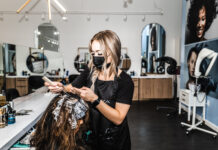 Modern Hair Salon Interior With Stylist At Work