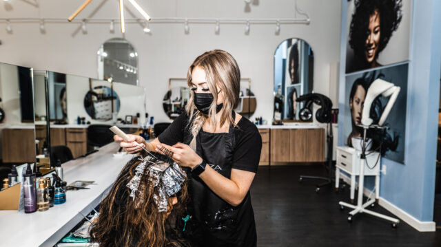 Modern Hair Salon Interior With Stylist At Work