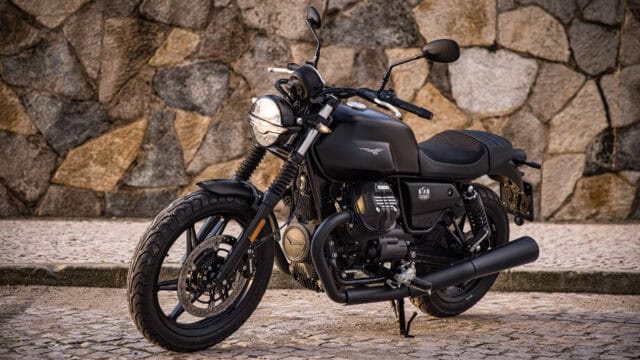 Moto Guzzi V7 Classic Black Motorcycle Parked on Cobblestone Street Wallpaper