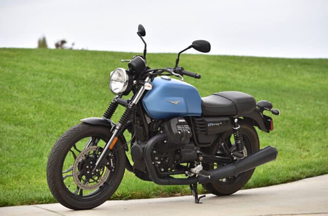 Moto Guzzi V7 Motorcycle Parked on Road with Green Grass Background Wallpaper