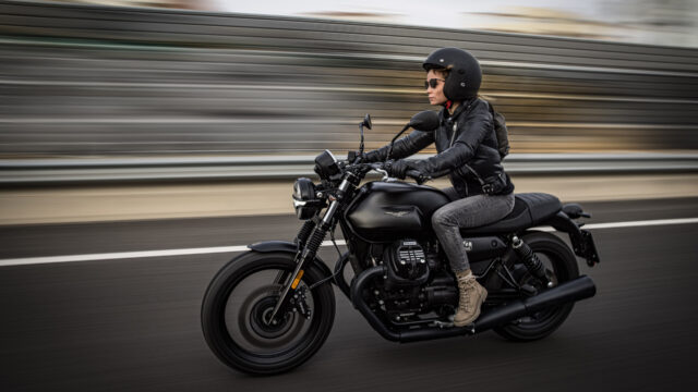 Moto Guzzi V7 Motorcycle Rider Speeding on Urban Road Wallpaper