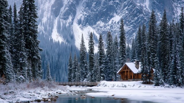 Nature full HD image wallpapers for laptops, a cozy cabin nestled in a snowy landscape with a backdrop of towering evergreen trees.