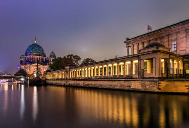 A beautiful cathedral with illuminated architecture reflecting on the calm river at night, HD Desktop Wallpaper
