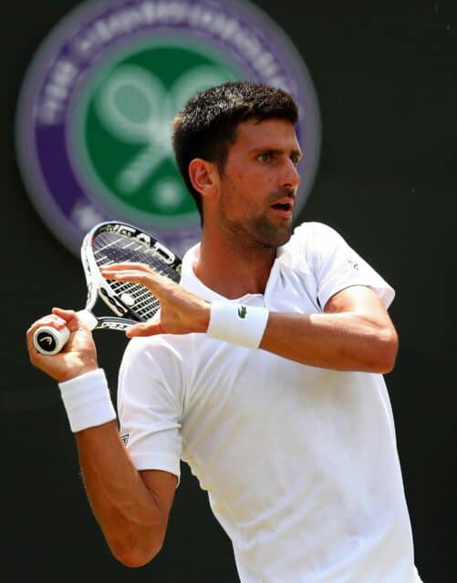 Novak Djokovic In Action At Wimbledon Tennis Match Wallpaper