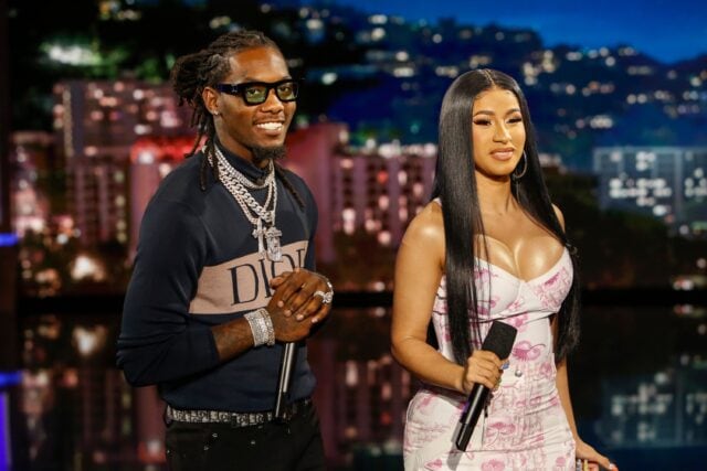 Offset Rapper and Cardi B Performing Together on Stage with City Lights Background